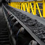 Förderband mit Kohle in industrieller Umgebung, geregelt durch esco-Frequenzumrichter mit Vektorregelung und Power-Ride-Through-Funktion.