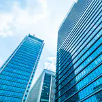 Moderne Bürogebäude mit gläserner Fassade – energieeffizient betrieben durch esco-Frequenzumrichter mit Fire Mode, Motorauslauf-Erkennung und Sparkennlinien.